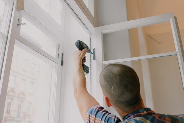  person installing window with a drill